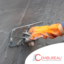 Worker applying cement on wall in construction site.