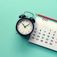 close up of calendar and alarm clock, planning for business meeting concept 