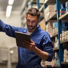 A man in a warehouse looking at a table