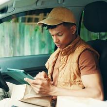 A delivery man checking a wrist device