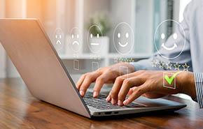 A person using a laptop to rate customer satisfaction with five-star feedback, showing online service quality