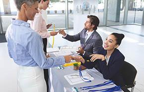 Business people checking in at conference registration table 